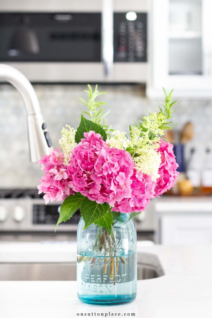 garden hydrangeas in blue ball jar on kitchen counter
