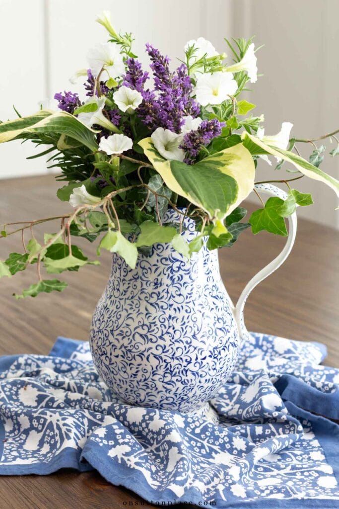 garden flower arrangement in pitcher with hosta ivy lavender petunias