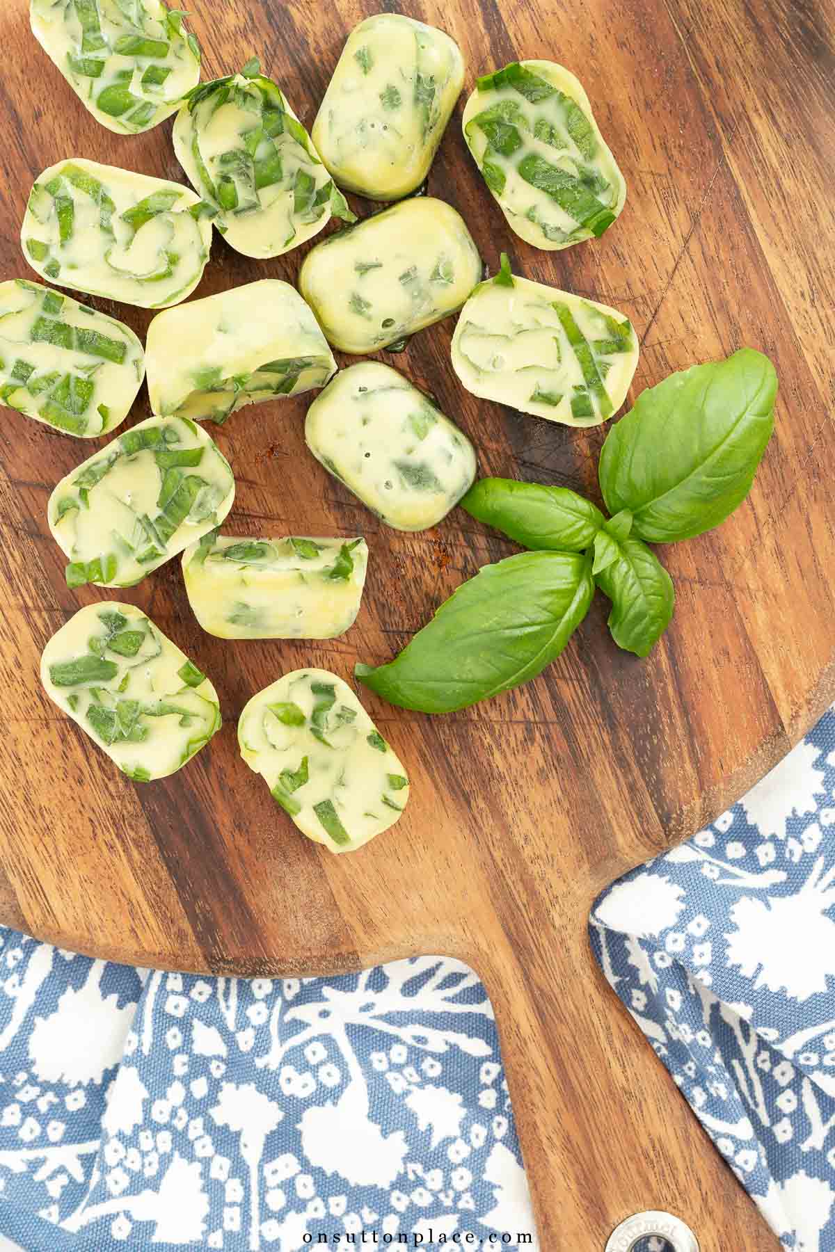 basil chiffonade in frozen olive oil on round wood board