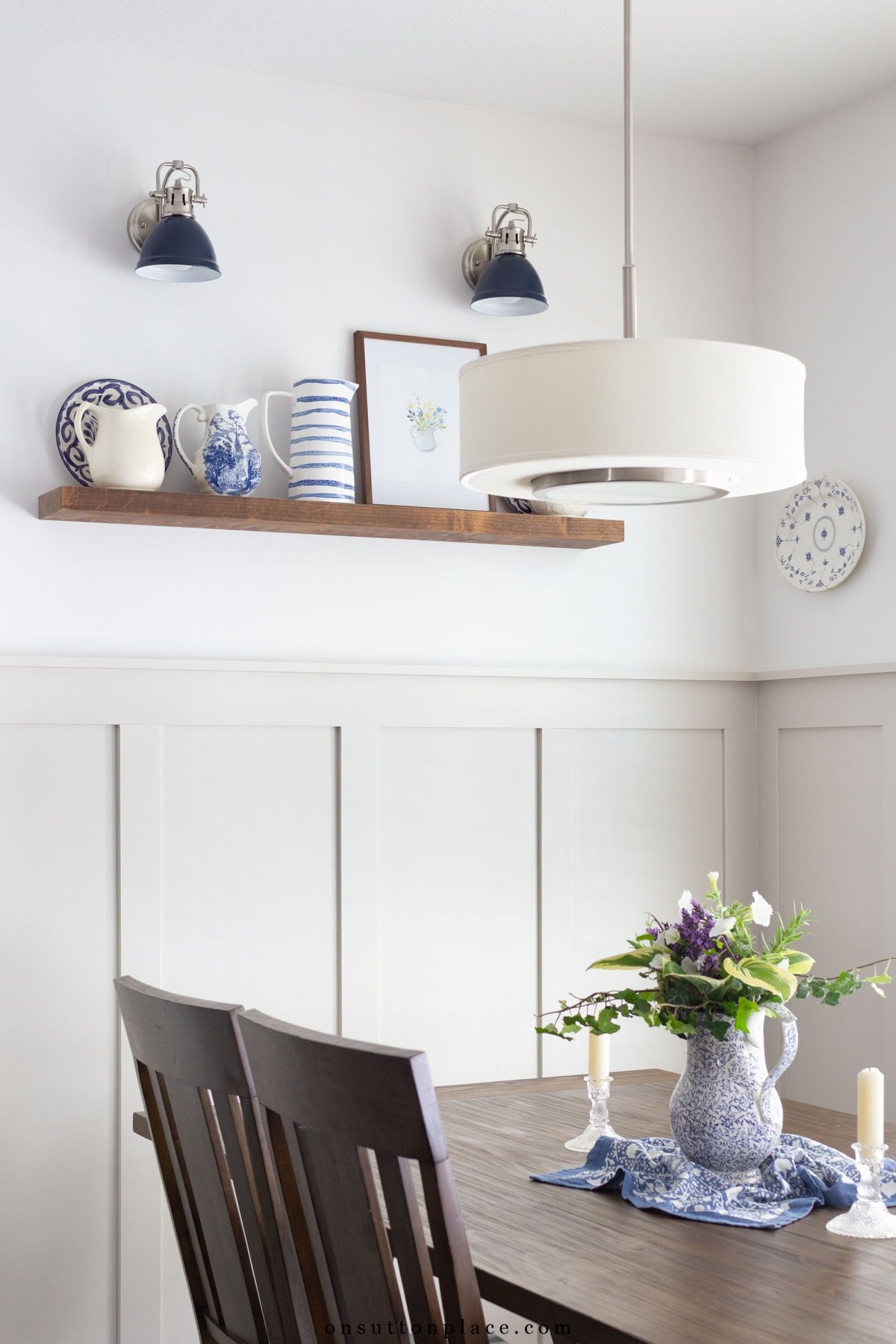 board and batten dining nook with blue wall sconces