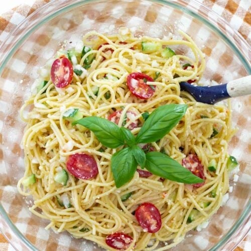 bowl of cold spaghetti salad recipe with basil sprig