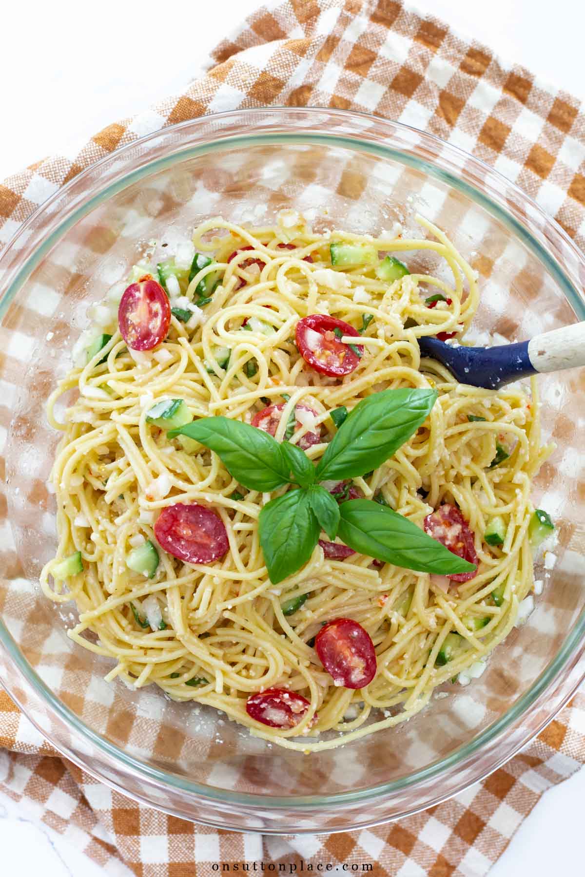 bowl of cold spaghetti salad recipe with basil sprig