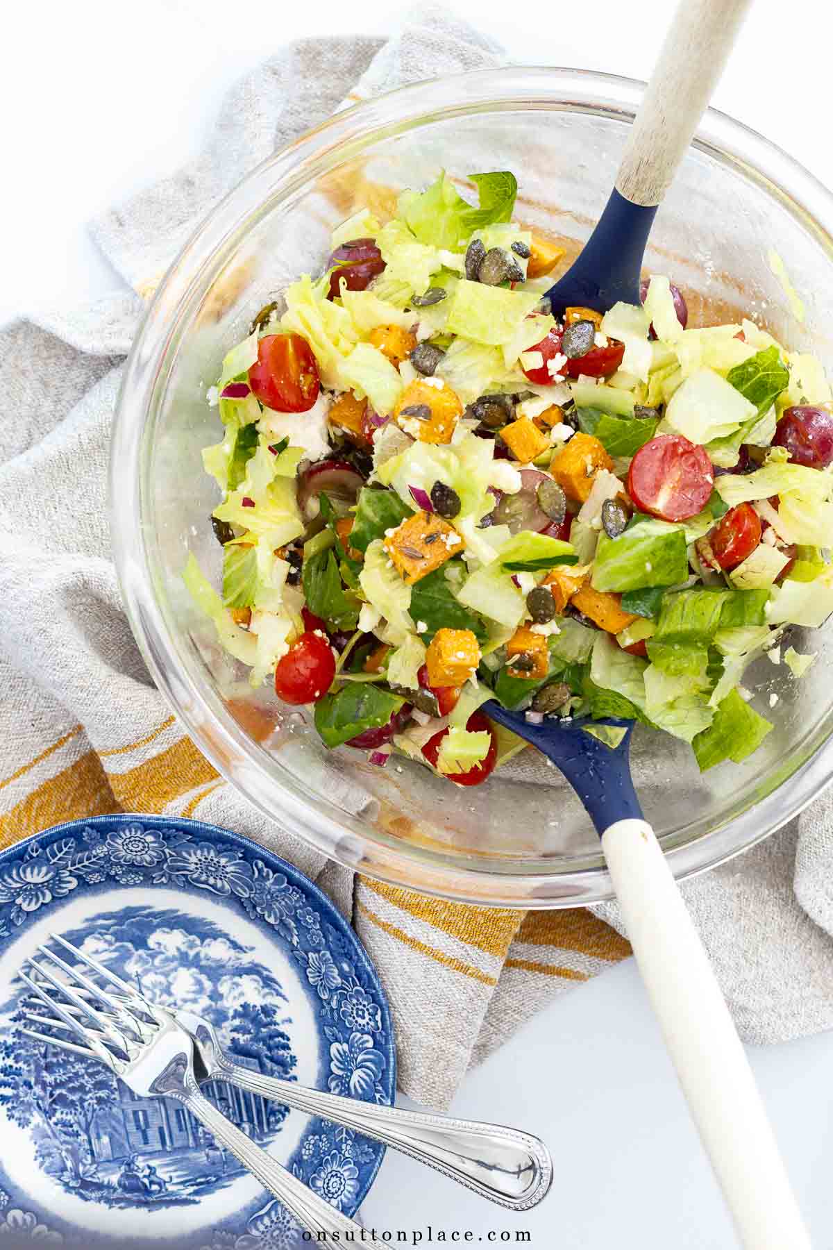 autumn romaine lettuce salad in large bowl with salad bowls and forks