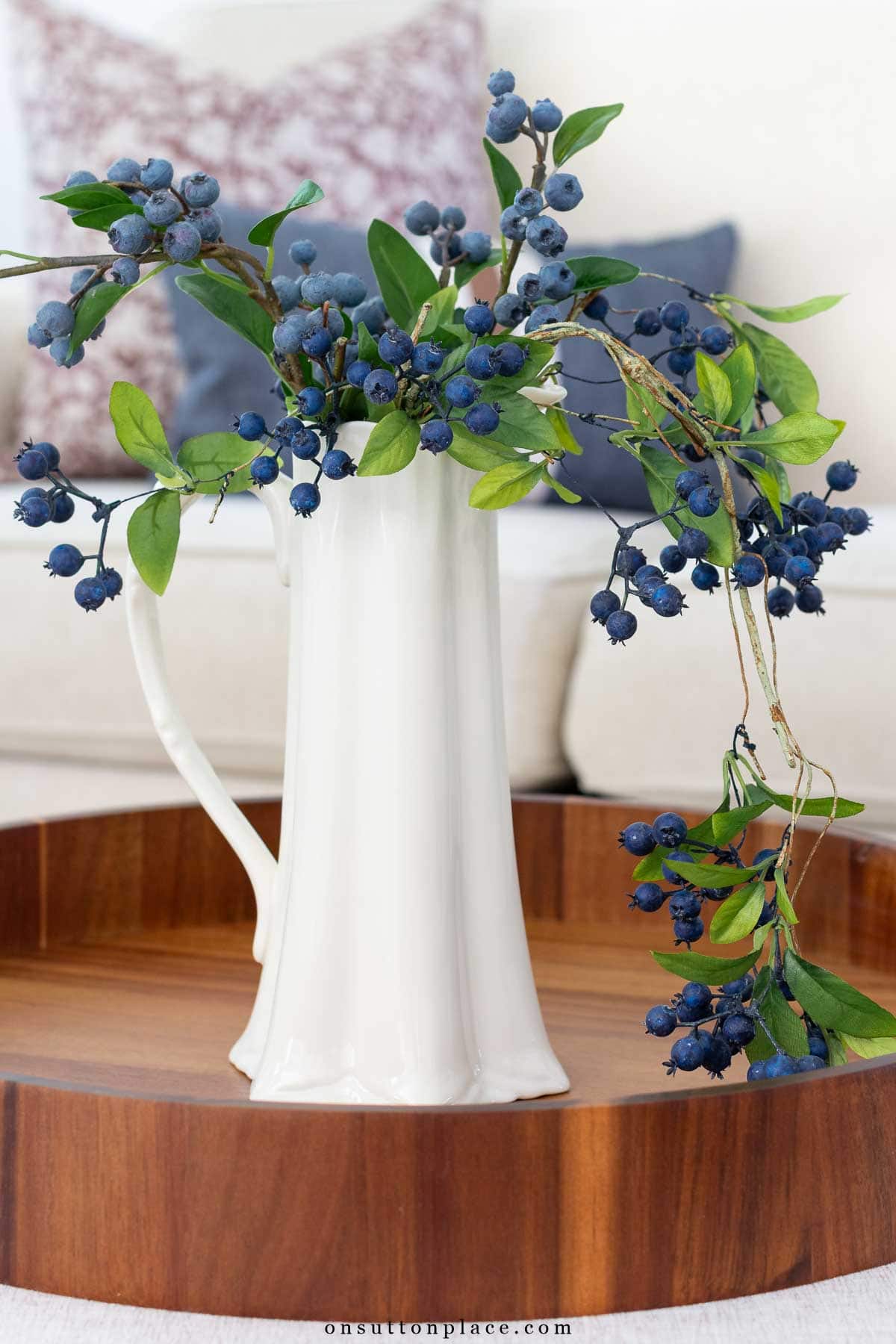 faux blueberries in tall white pitcher