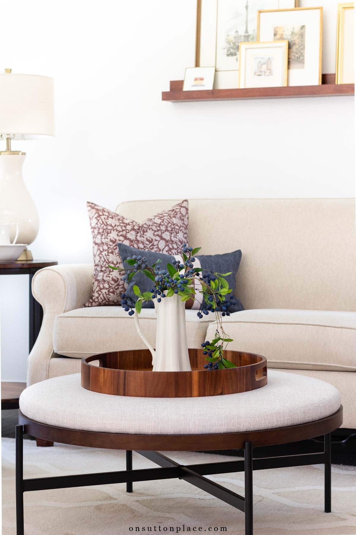 ottoman with round tray and pitcher of faux blueberries