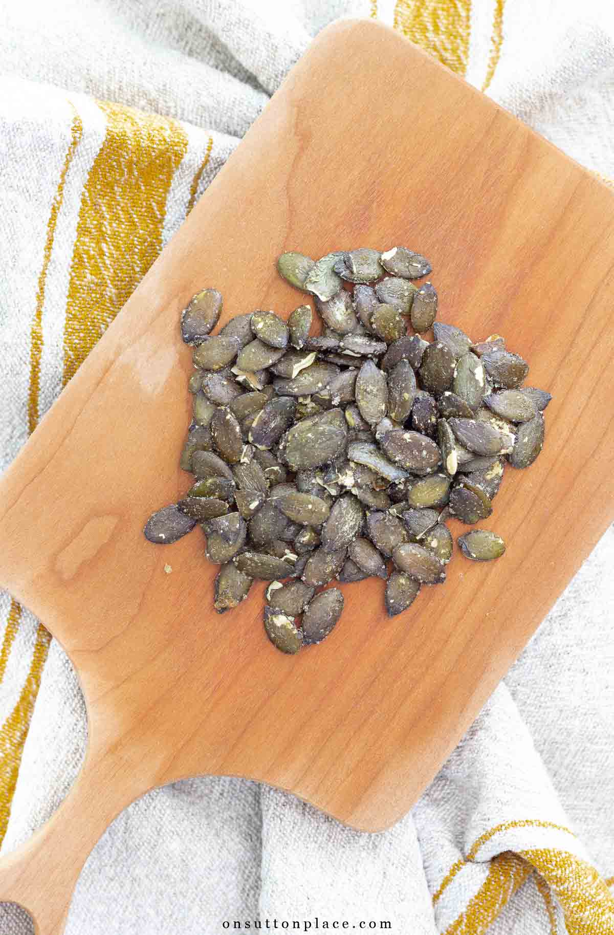 roasted pepitas on small wood cutting board