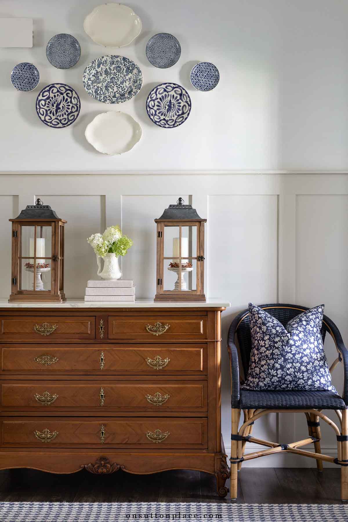 vintage dresser in foyer with plate wall