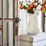 wood lantern with tiny tassel stack of books and flowers
