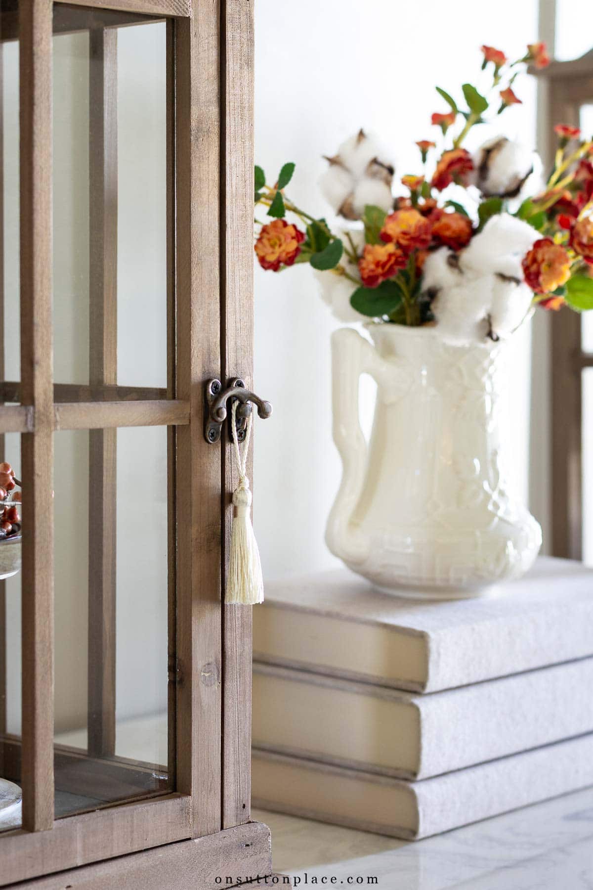 wood lantern with tiny tassel stack of books and flowers