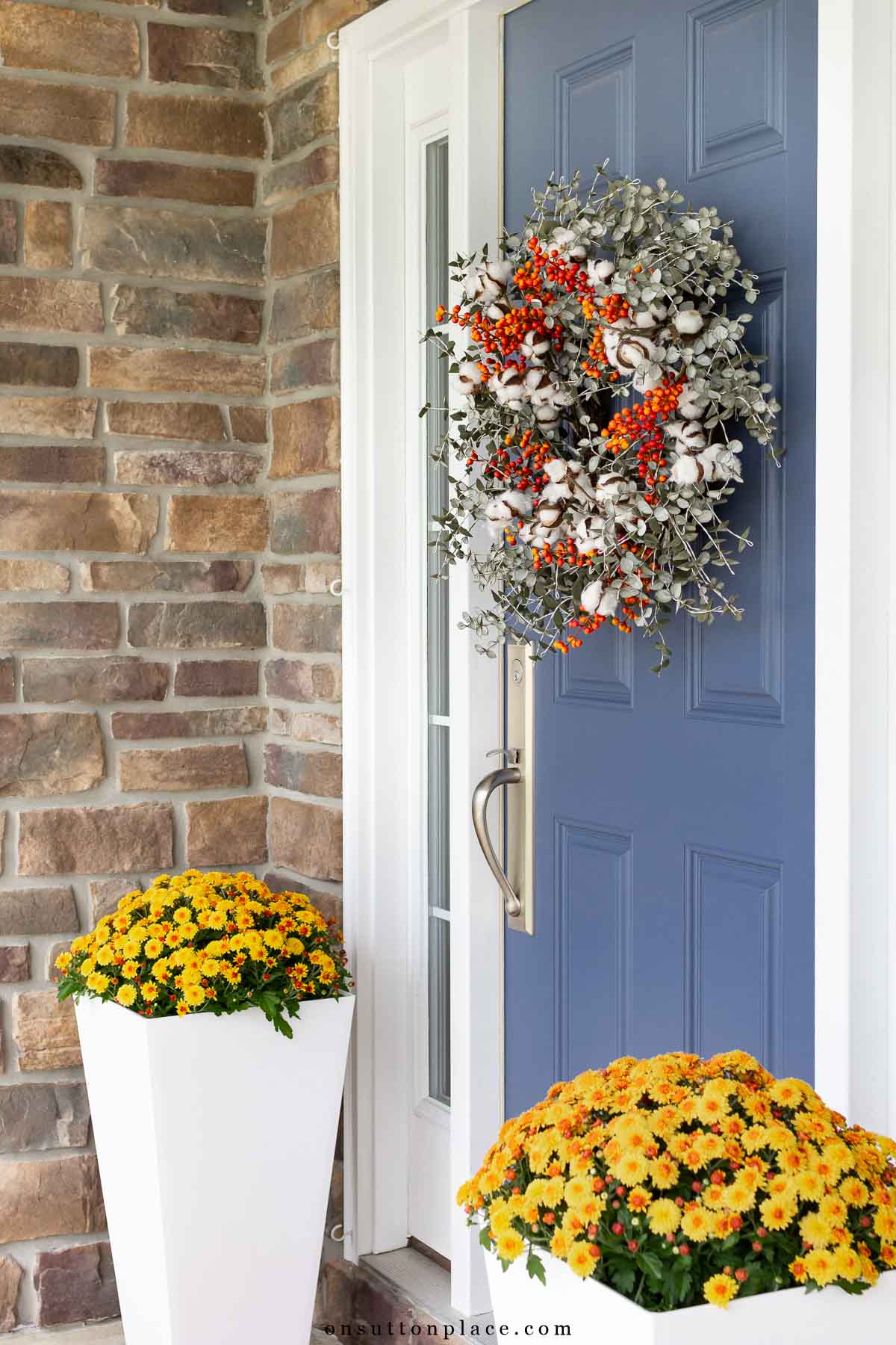 blue front door with fall wreath and mum planters-12