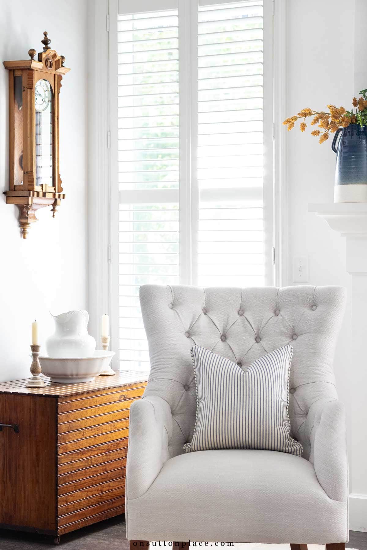 lovely corner of neutral living room with heirloom clock antique blanket chest vintage pitcher and bowl