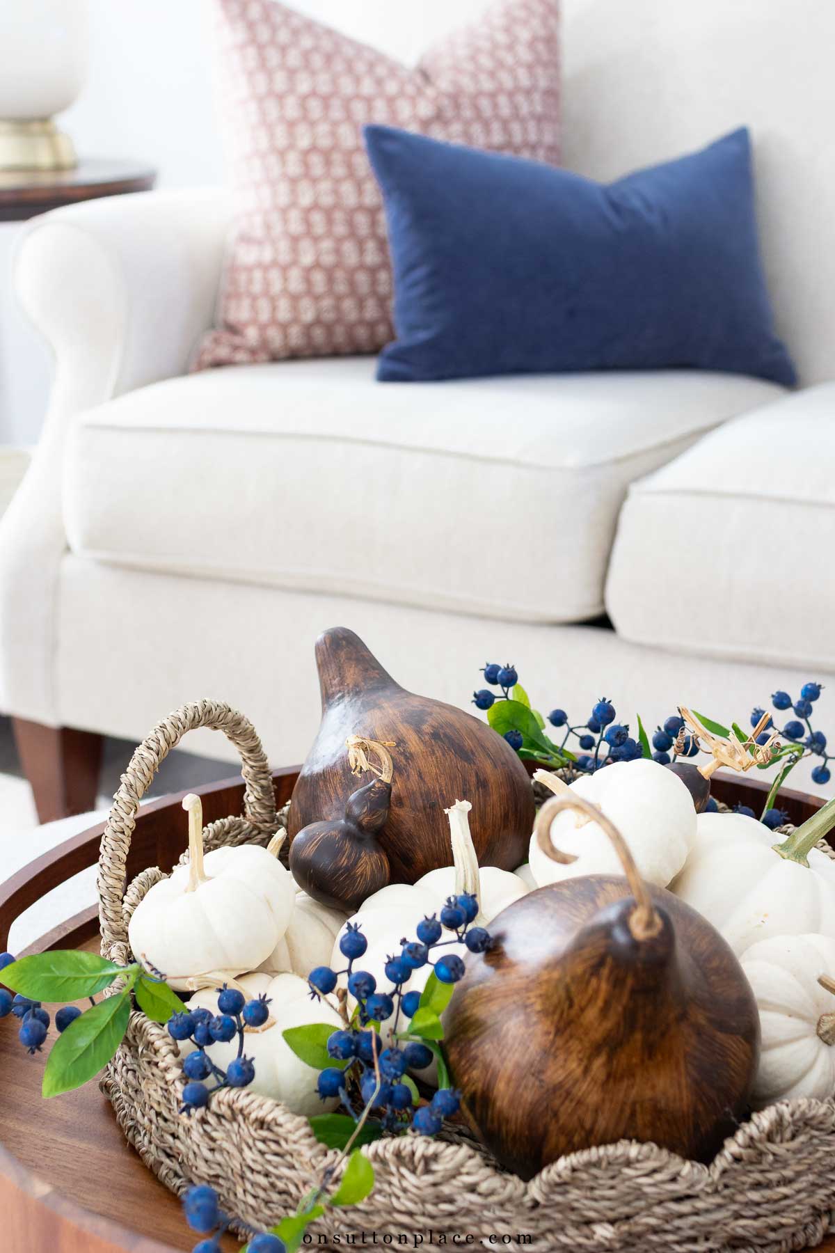 round rattan tray layered on wood tray with pumpkins and gourds