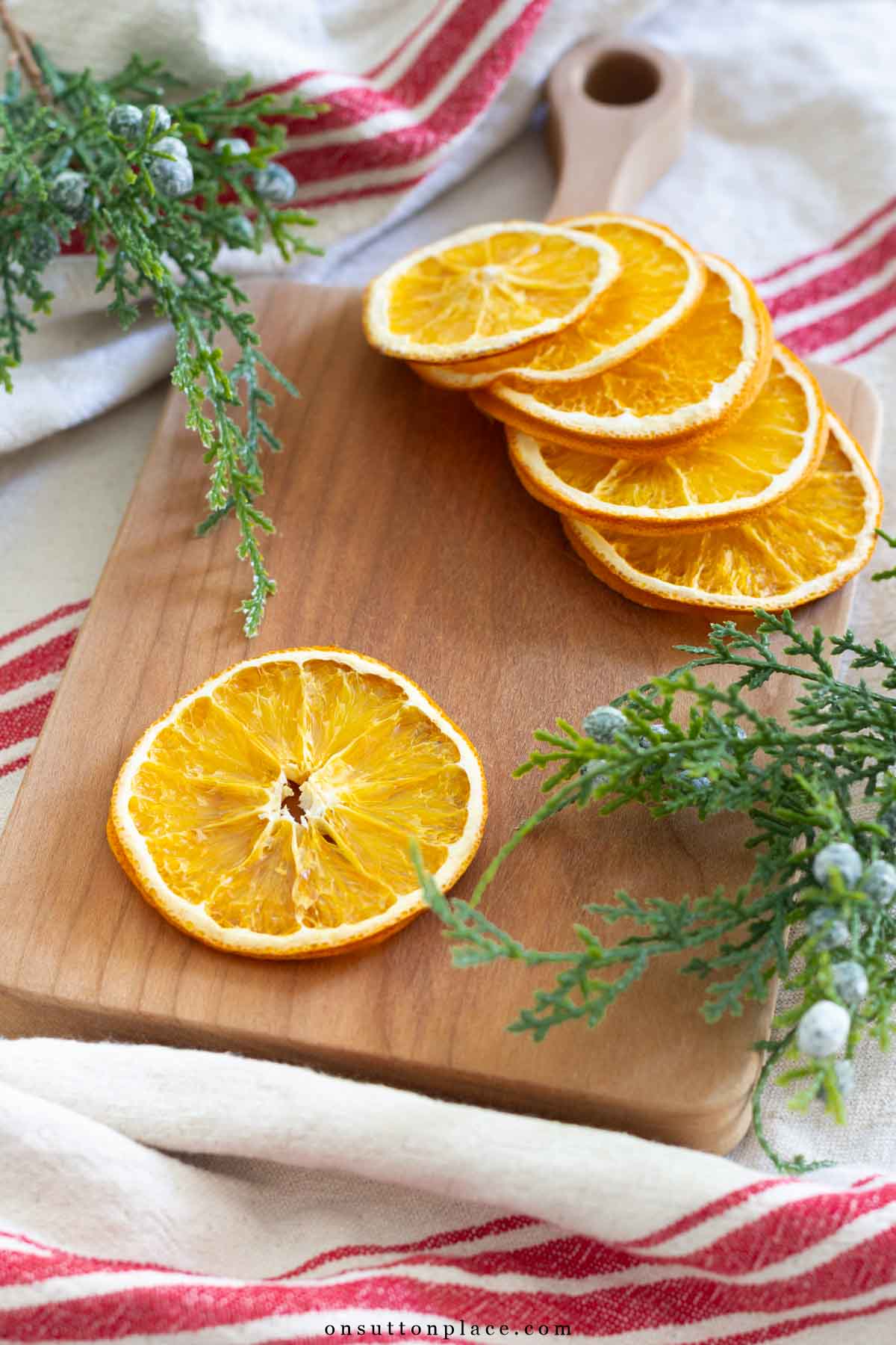 dried orange slices on wood board with greenery