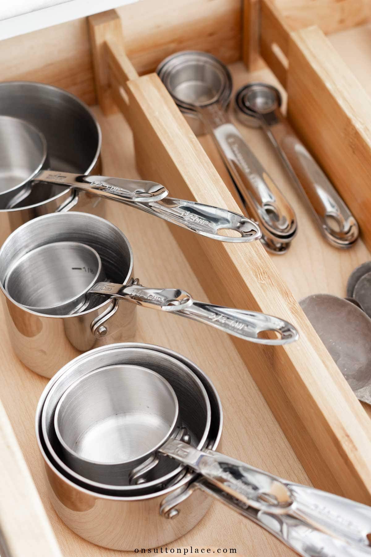 measuring cups and spoons in organized drawer minimalist kitchen essentials