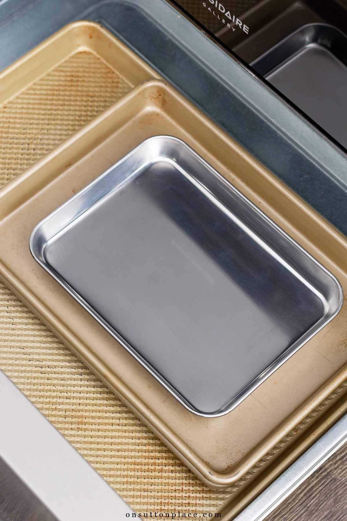 sheet pans in bottom drawer of stove minimalist kitchen essentials