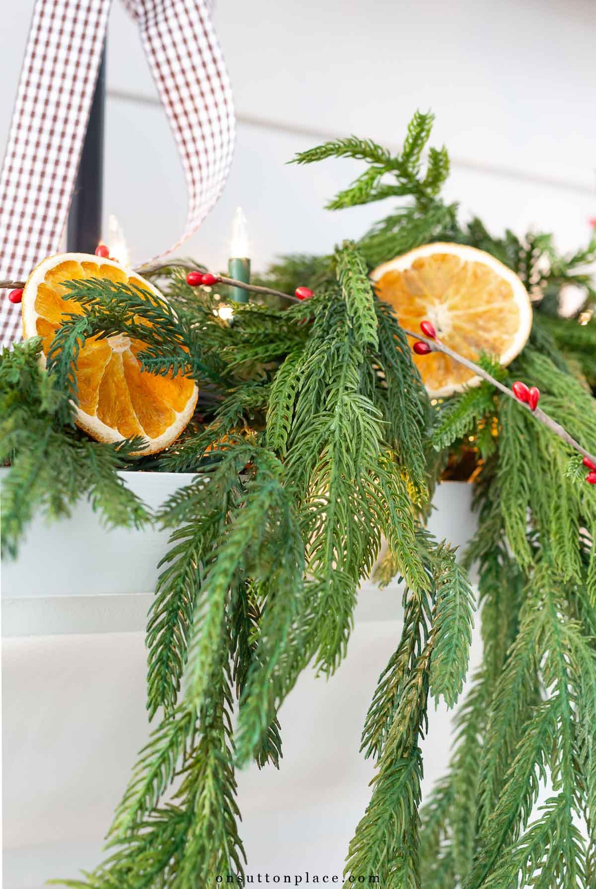 Christmas decor dried oranges in Norfolk pine garland on mantel