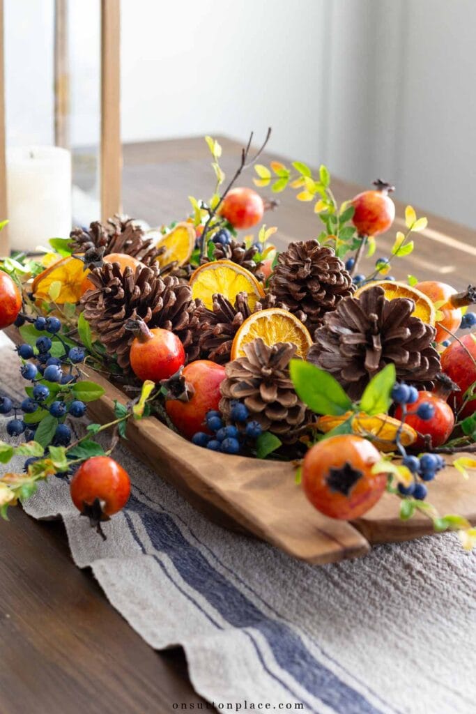 holiday centerpiece in dough bowl with pinecones, dried orange slices, pomegranates