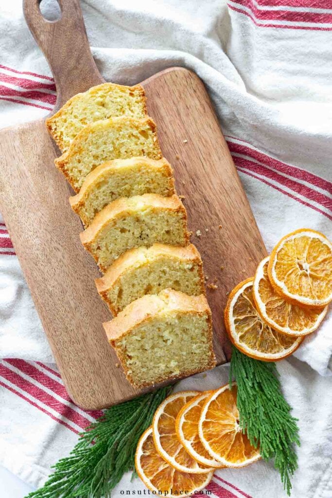 orange bread recipe loaf sliced on wood board with dried orange slices