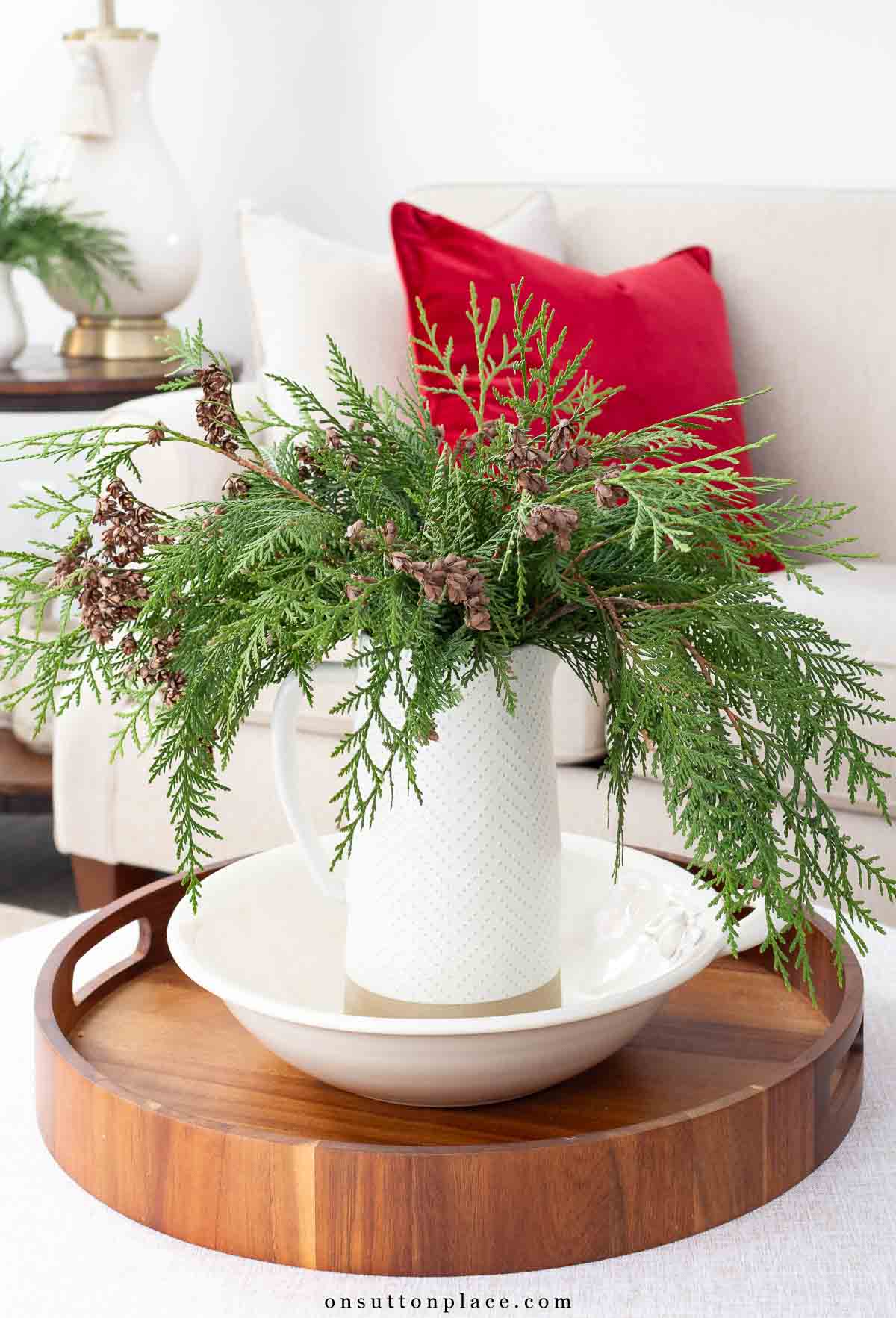 Christmas decor fresh pine branches in pitcher on coffee table