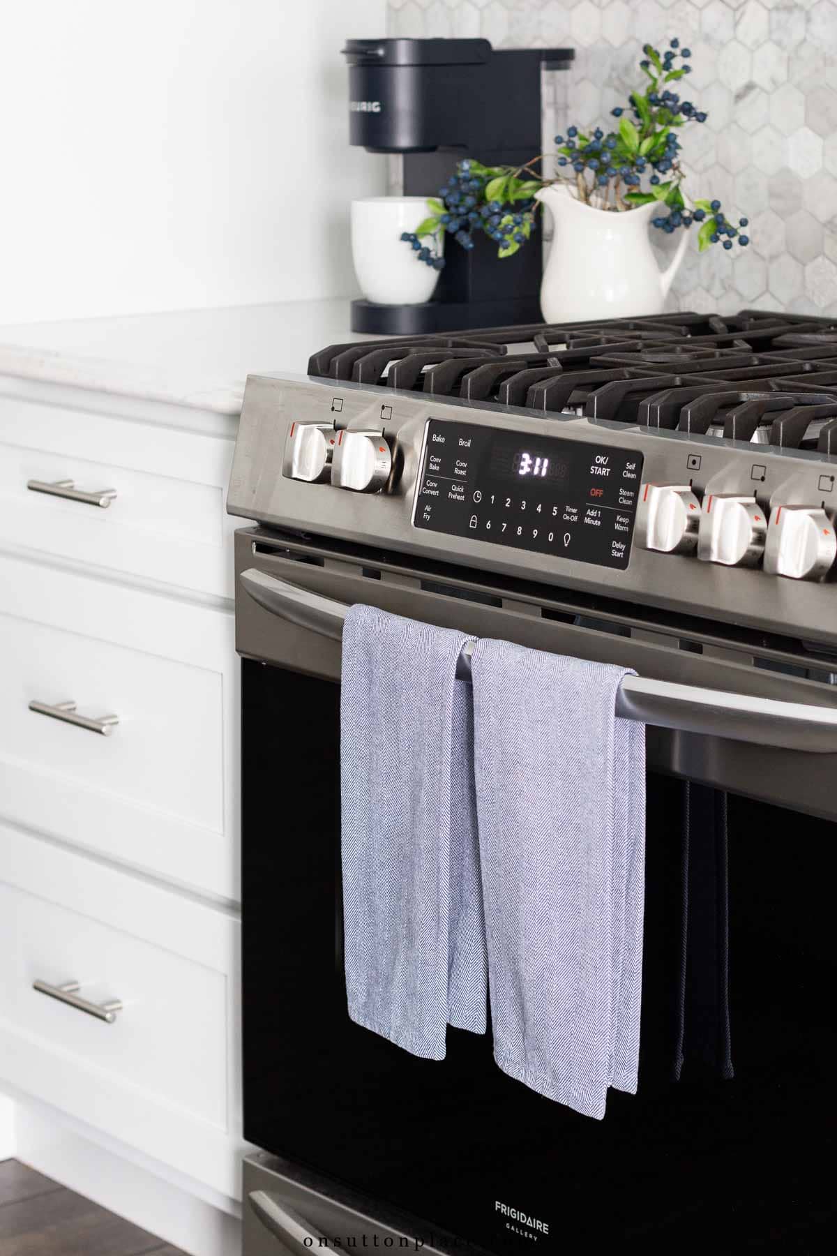 kitchen towels on front handle of stove