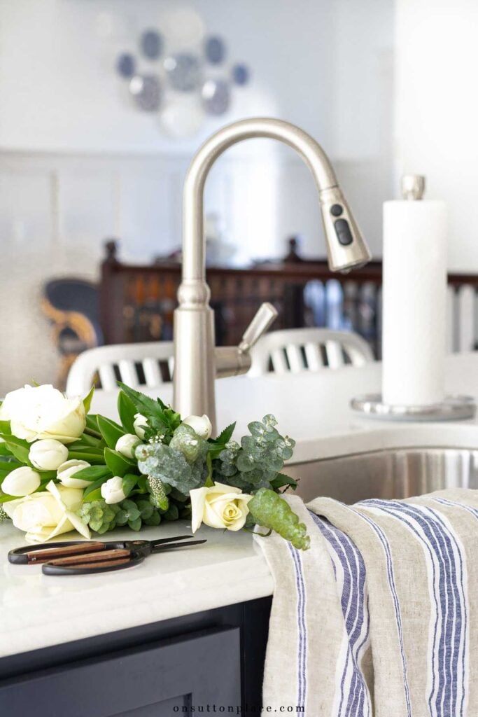 tulips roses eucalyptus in kitchen sink with vintage towels