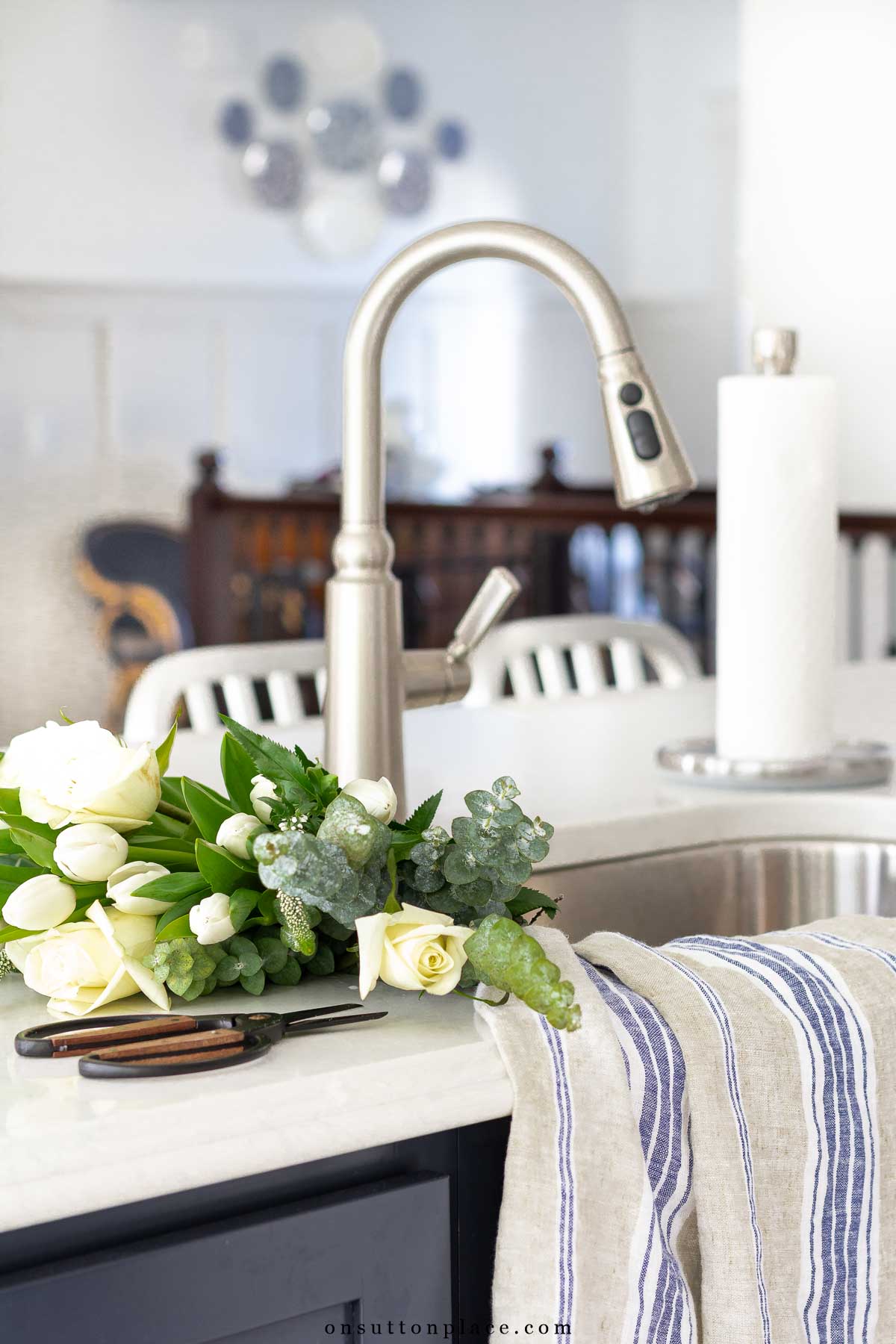 tulips roses eucalyptus in kitchen sink with vintage towels