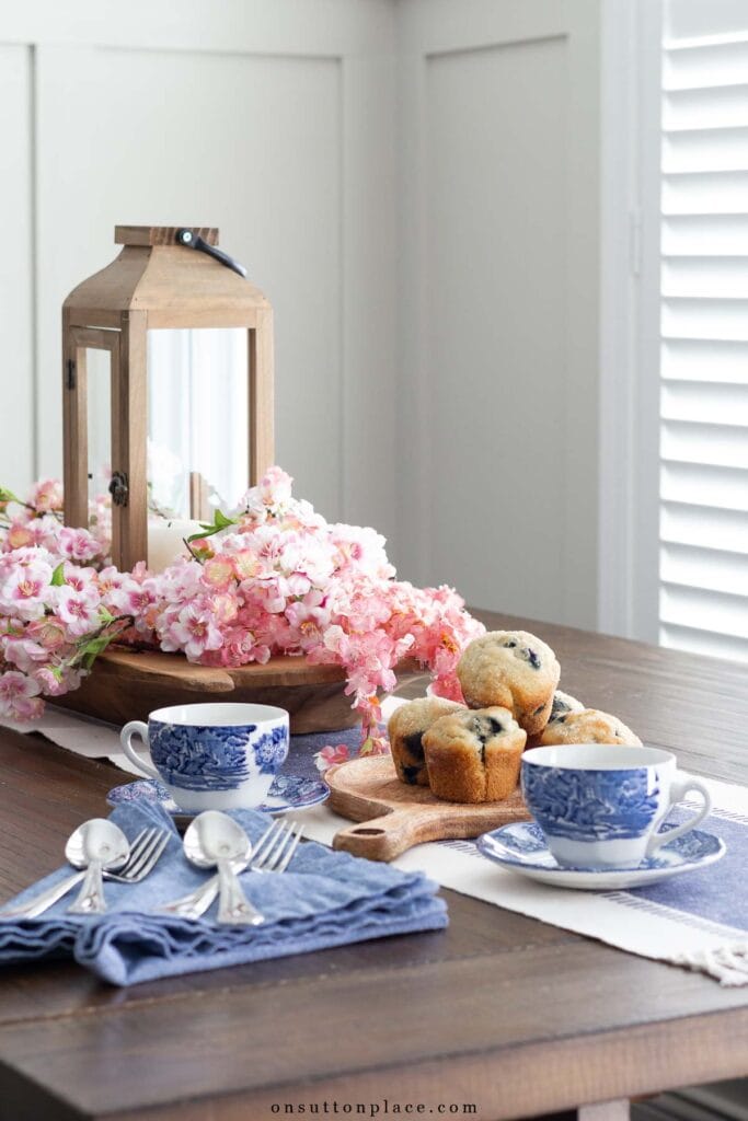 a well kept home dining nook table with coffee cups and muffins