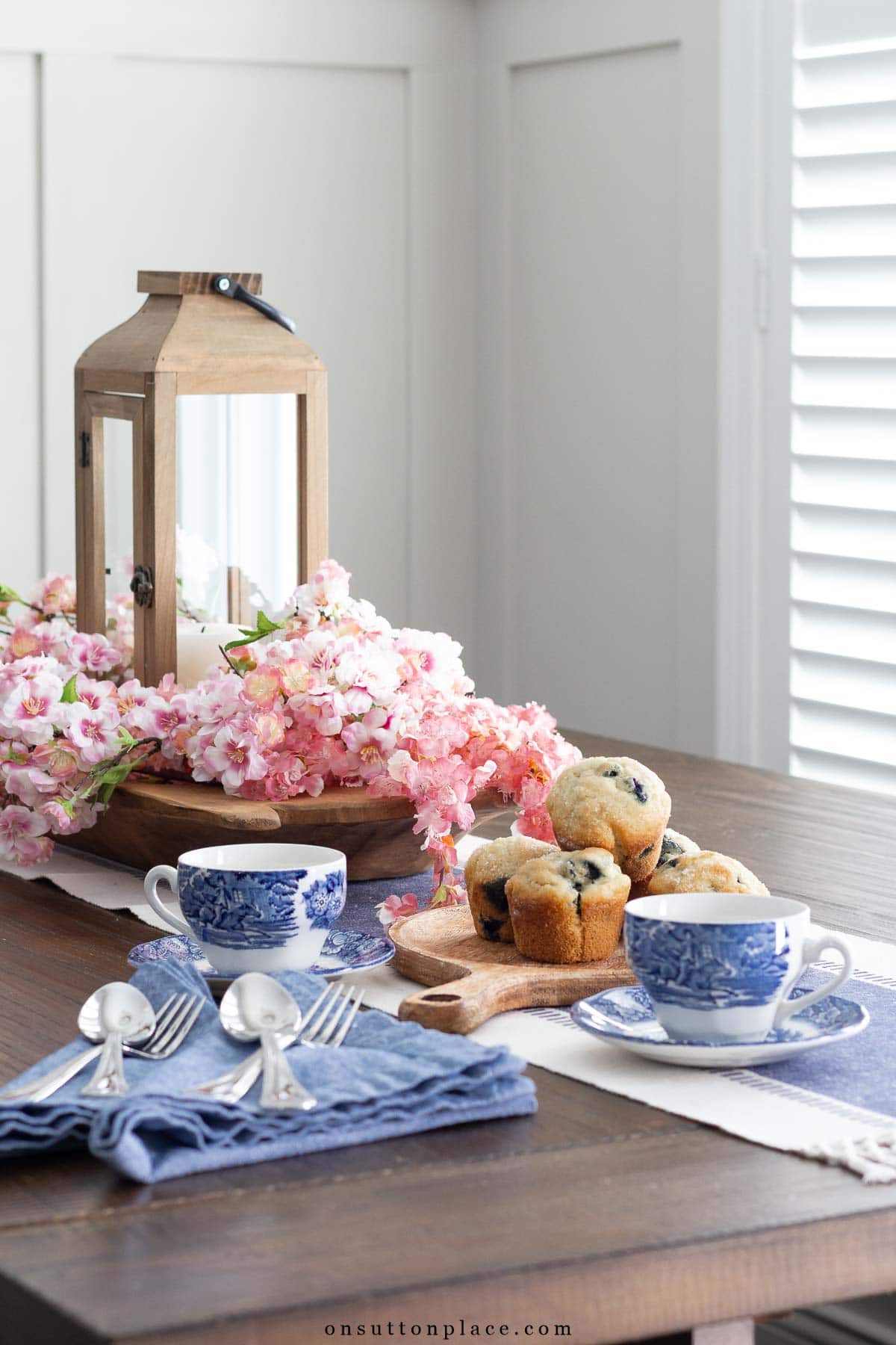 a well kept home dining nook table with coffee cups and muffins