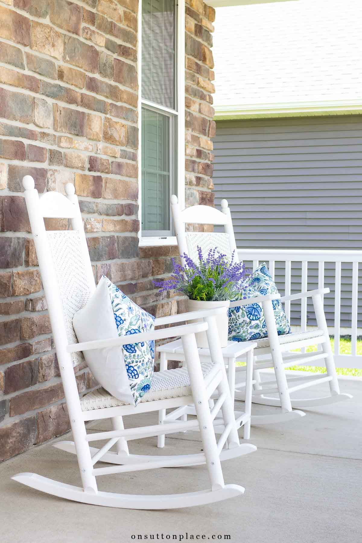 simple concrete front porch with white rockers in summer