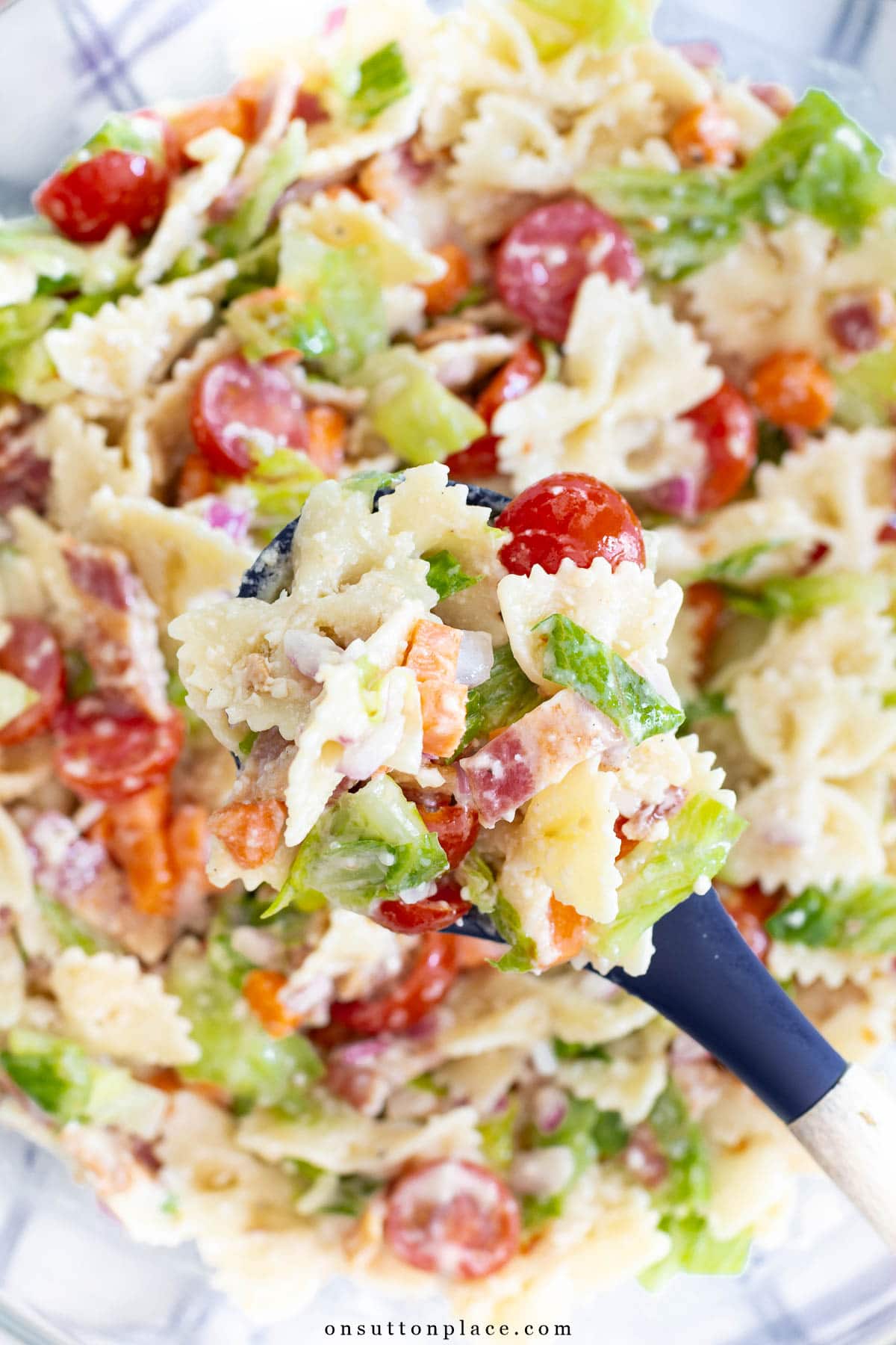 BLT pasta salad recipe in bowl with spoon farfalle