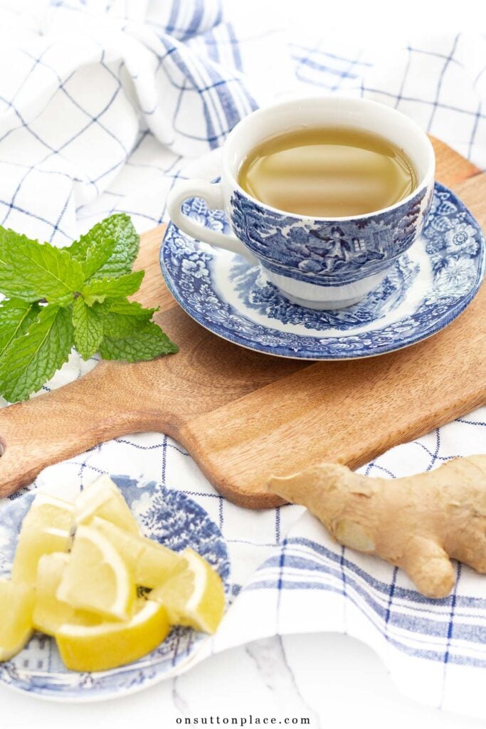 ginger tea recipe in blue cup and saucer with mint lemon