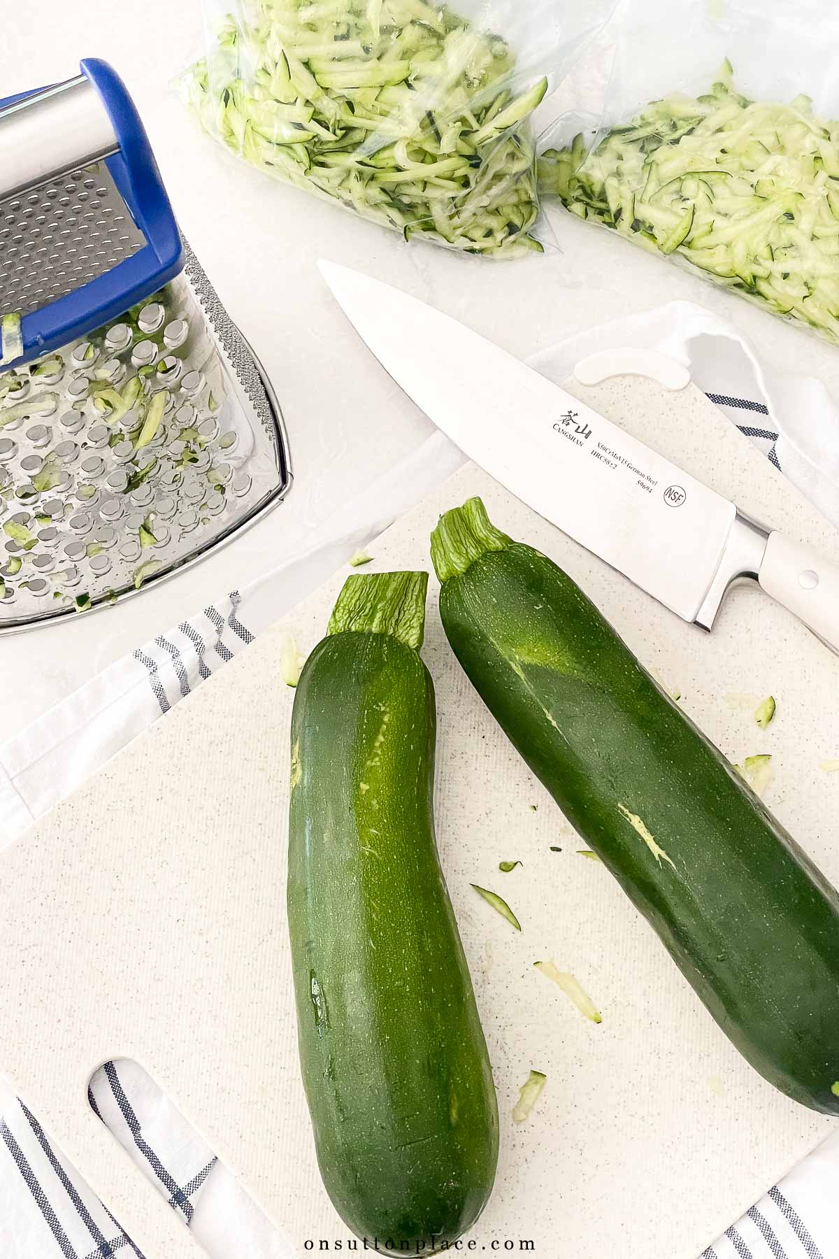 large zucchini with grater and shredded zucchini in bags