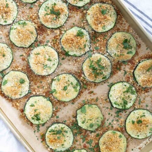roasted zucchini recipe baked on parchment paper baking sheet