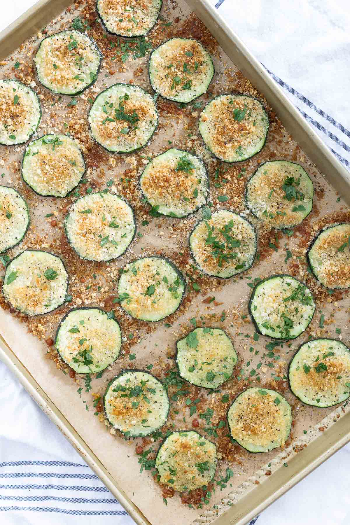 roasted zucchini recipe baked on parchment paper baking sheet
