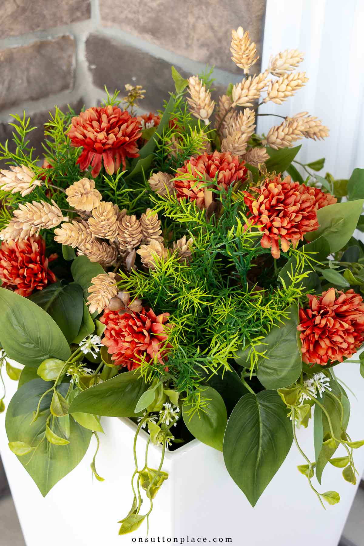 faux greenery and flowers in white planter for fall