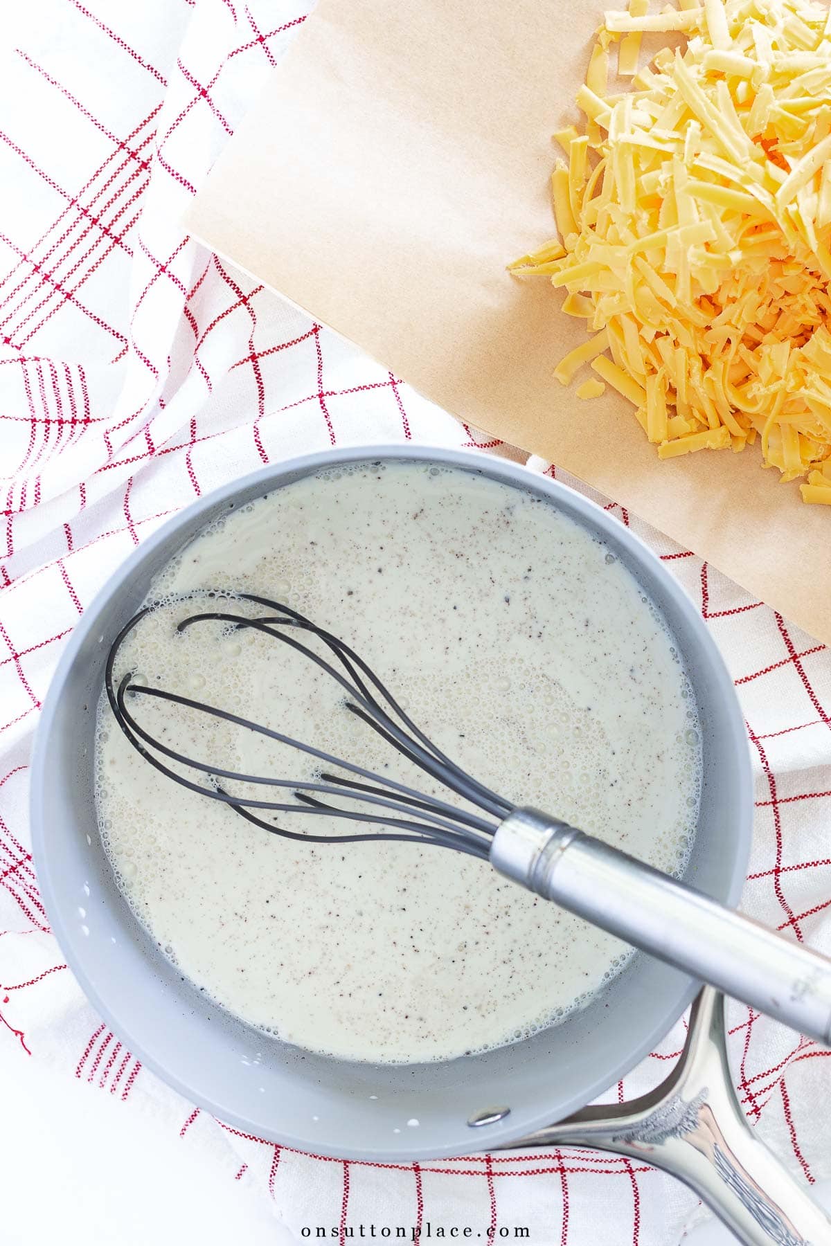 delmonico potatoes recipe saucepan with milk topping and cheese
