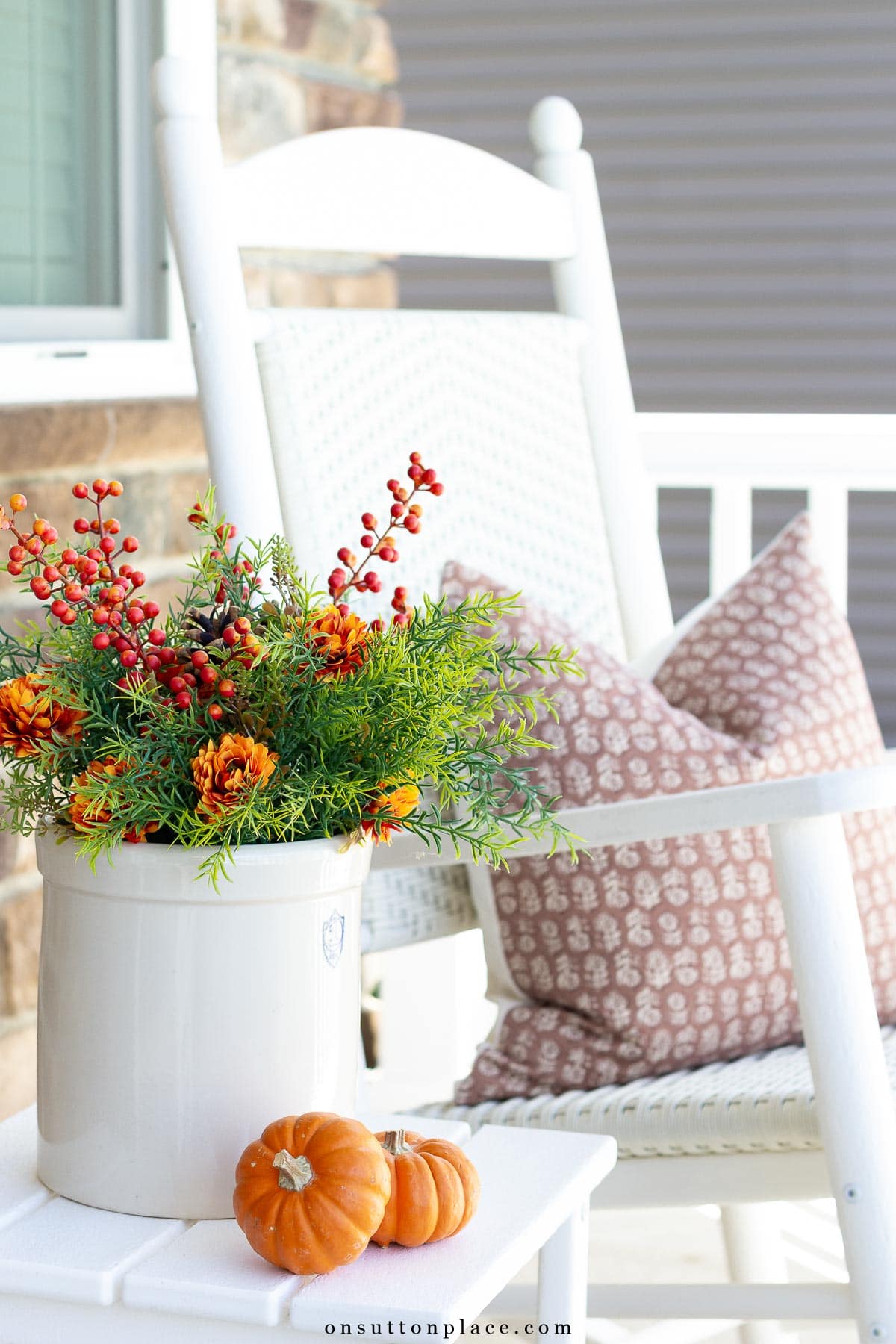 simple fall porch decor with crock of greenery and mini pumpkins